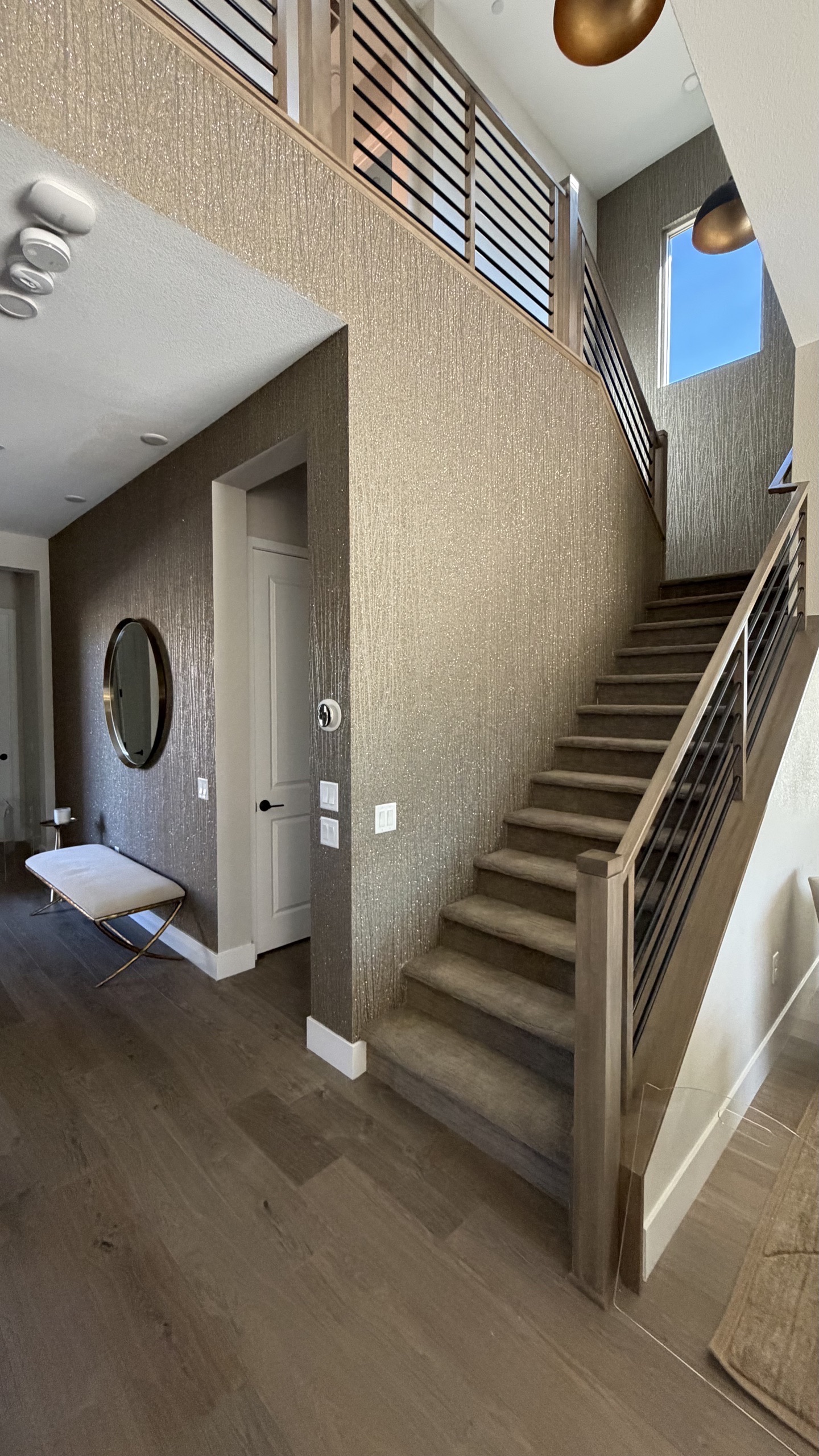 Entryway and staircase with bronze textured wallcovering